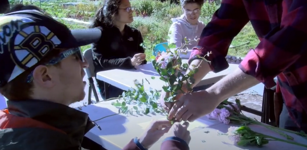 two people helping each other make a bouqet of flowers